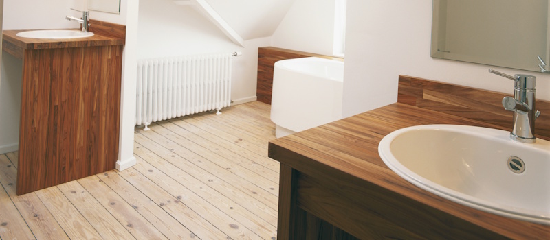 Gerenoveerde houten vloer in moderne badkamer met lichte afwerking