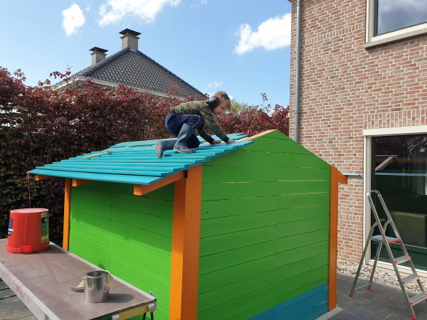 De geschilderde planken worden op het dak getimmerd